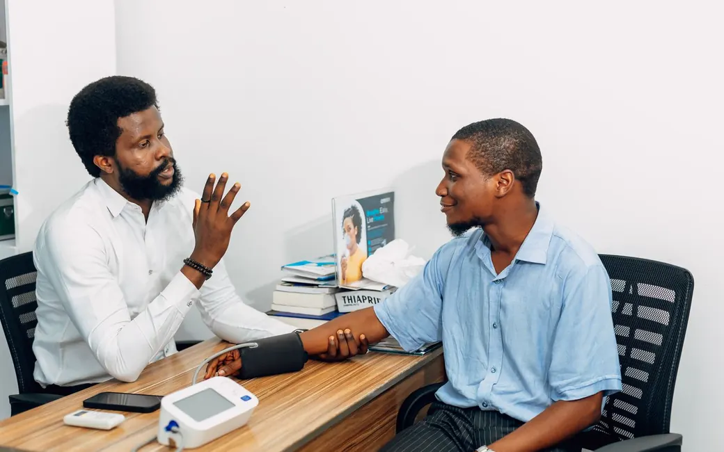A doctor talking with a patient across the desk