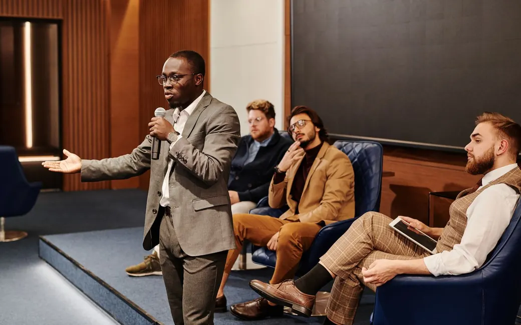 A speaker addressing a full conference room
