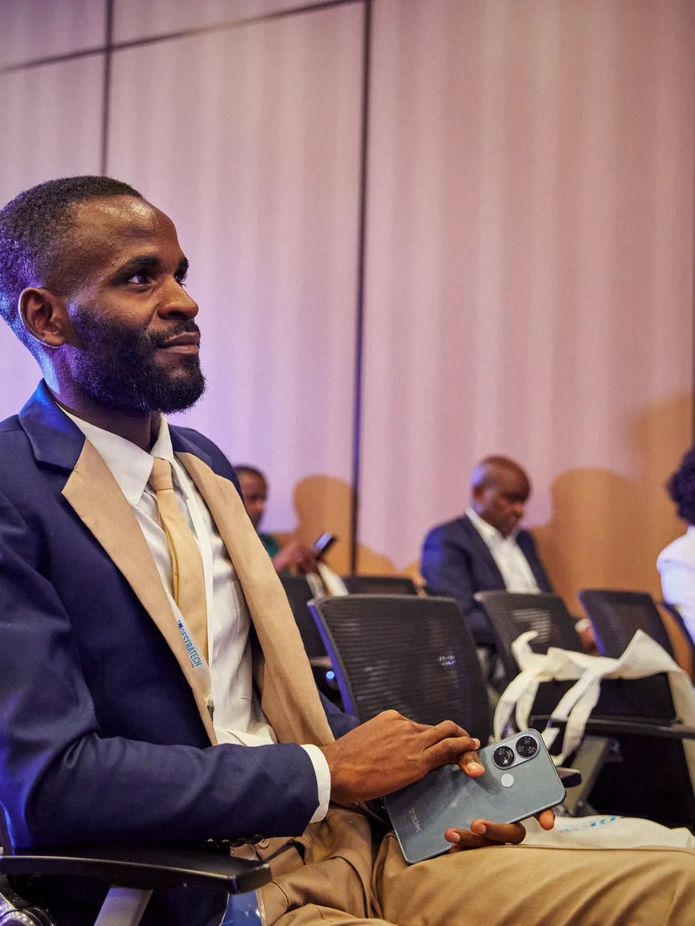 A delegate seated in the audience at a conference