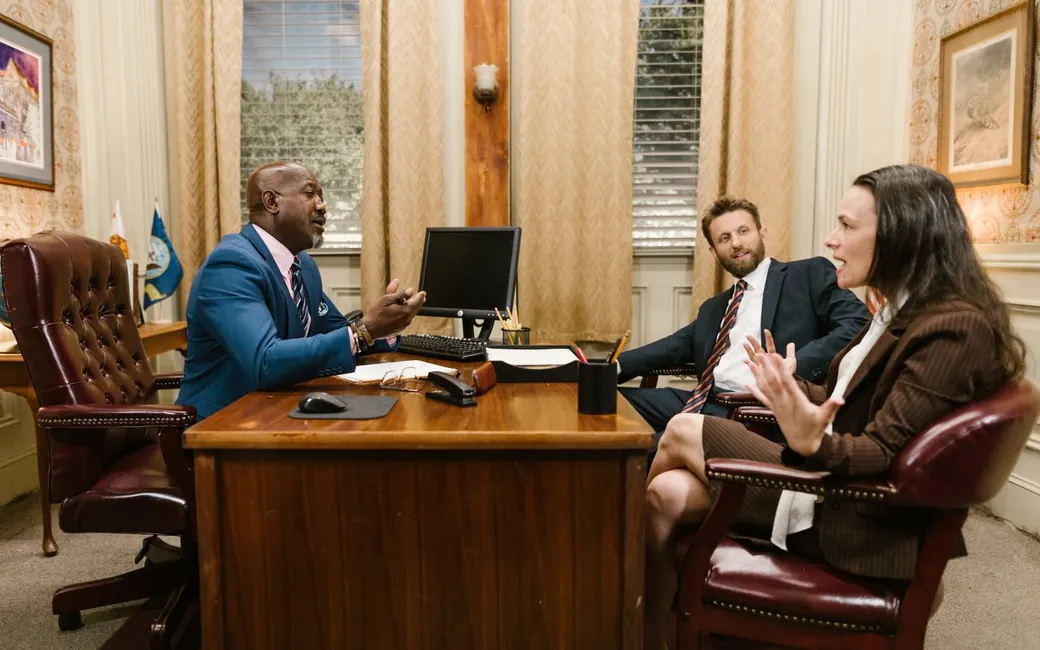 A lawyer at his desk advising two clients