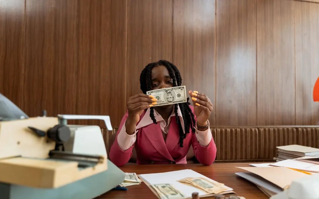 A teller checking a banknote at the counter